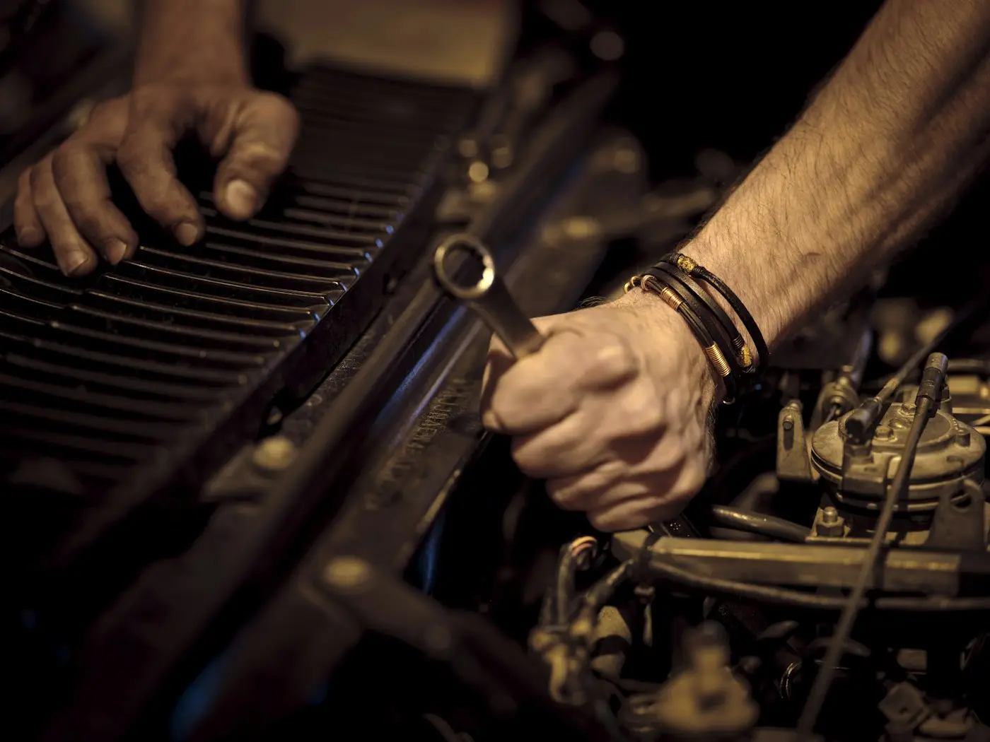 Hands working on an engine with a wrench