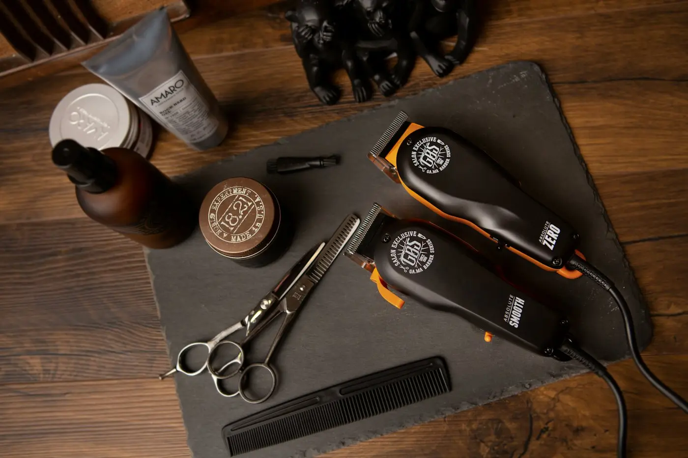 Clippers, scissors and comb on a slate tray